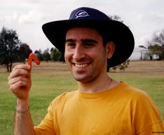 Photo of man holding  a tiny  boomerang.